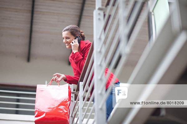 Young woman on cellphone in shopping mall