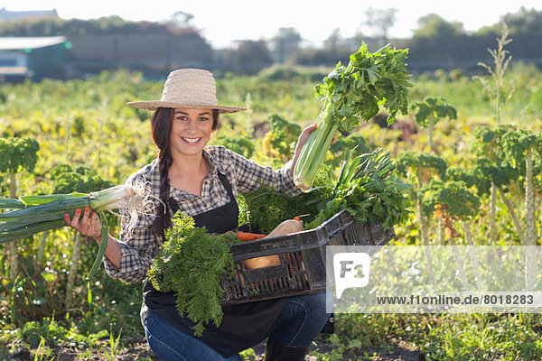 Young woman with vegetables grown at farm