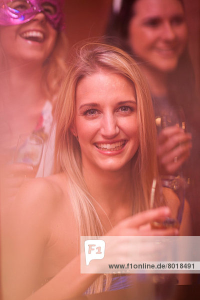 Junge Frau mit blonden Haaren mit Weinglas
