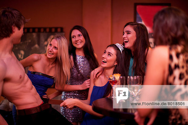 Young women watching male stripper at hen party