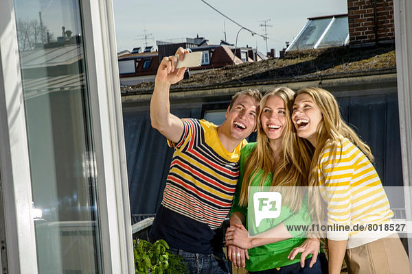 Drei junge Freunde  die sich auf dem Dach fotografieren.
