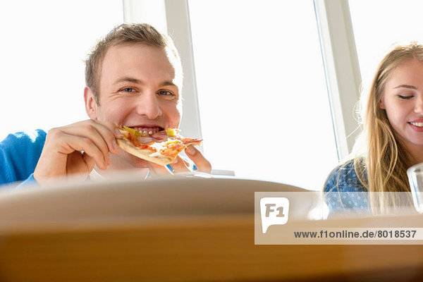 Junger Mann beim Pizzaessen
