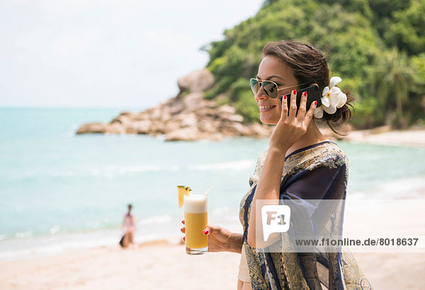 Woman using mobile phone on beach  Banyon Tree Resort  Ko Samui  Thailand