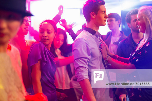 Teenagermädchen mit Händen auf der Brust des Jungen auf der Party