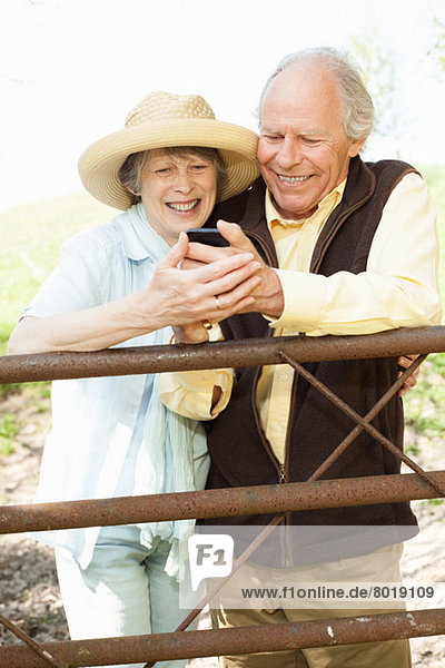 Seniorenpaar lächelt Nachricht auf dem Handy an