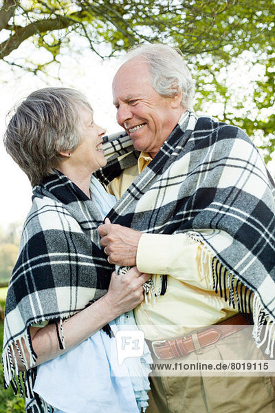 Senior couple wrapped in shawl together
