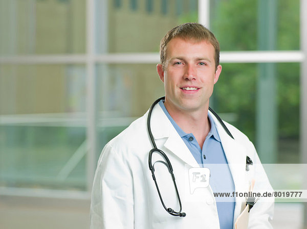 Mid adult doctor with stethoscope smiling  portrait