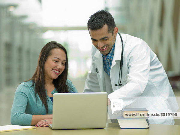 Mid Erwachsenen Arzt mit Laptop mit jungen Studenten  lächelnd