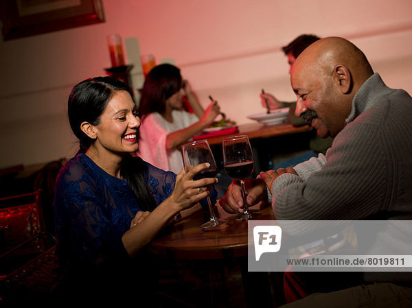 Couple enjoying wine in restaurant  smiling