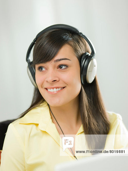 Young woman wearing headphones and smiling
