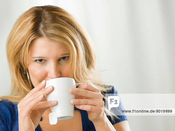 Mid adult woman drinking from cup  portrait