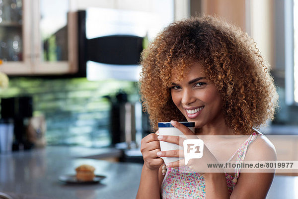 Mittlere erwachsene Frau genießt Kaffee in der Küche  Porträt