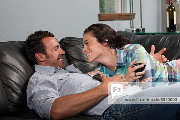 Young couple relaxing on sofa  smiling