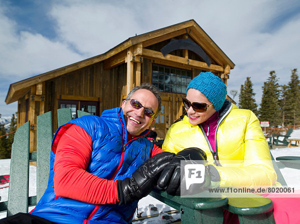 Erwachsener Mann und junge Frau entspannen gemeinsam im Skigebiet  Portrait