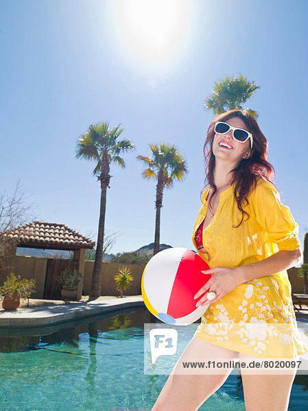 Junge Frau mit Strandball am Pool  Portrait