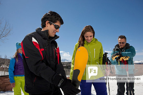 Mature man and young woman with ski instructors on ski slope