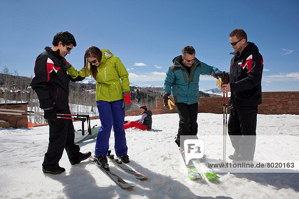 Mature man and young woman with ski instructors on ski slope