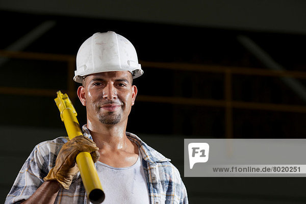 Mittlerer Erwachsener Bauarbeiter mit Schutzhelm und Haltewerkzeug  Porträt