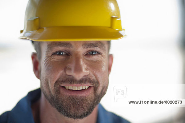 Mittlerer erwachsener Bauarbeiter mit Schutzhelm  lächelnd