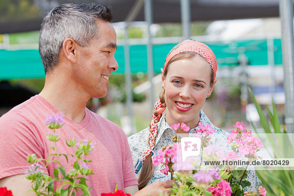 reifer Mann und mittlere erwachsene Frau beim Einkaufen im Gartencenter  lächelnd