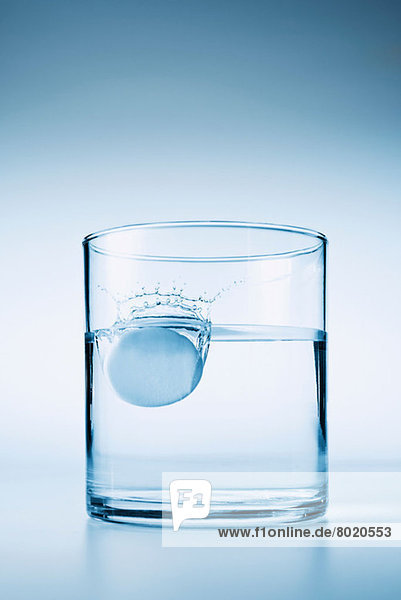 Tablette  die in ein Glas Wasser fällt