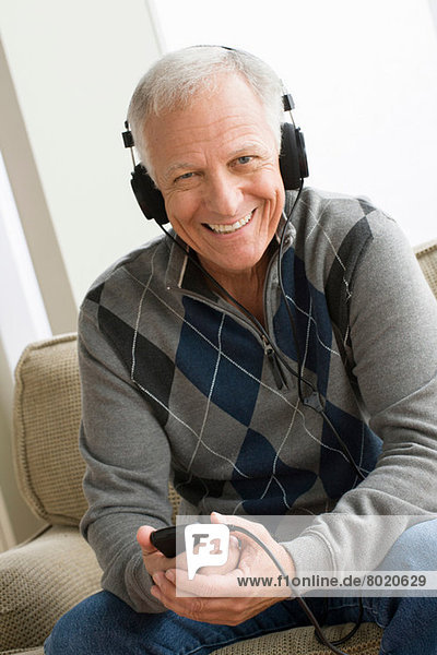 Senior Mann mit Kopfhörer und Musik hören
