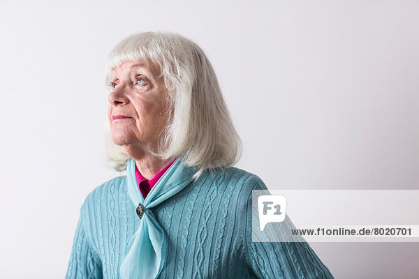 Ältere Frau mit grauen Haaren schaut weg