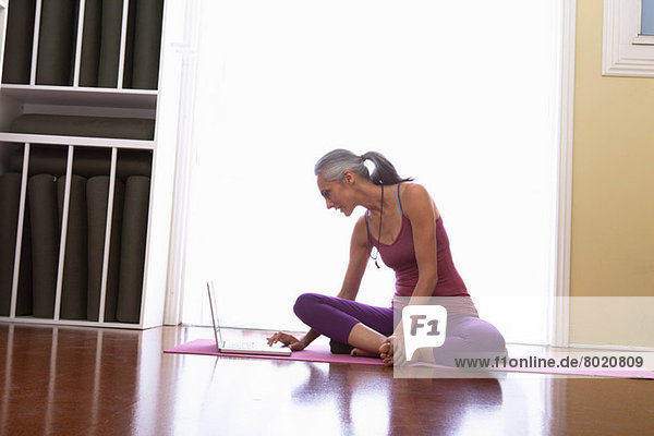 Woman using laptop sitting cross legged