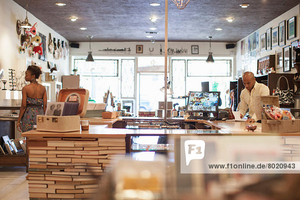 Junge Frau im Vintage-Shop mit Ladenbesitzerin