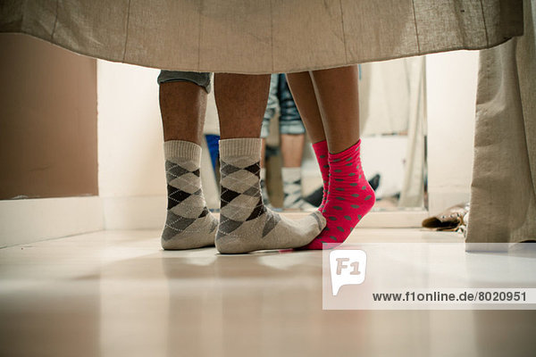 Young couple wearing socks in changing room  low section