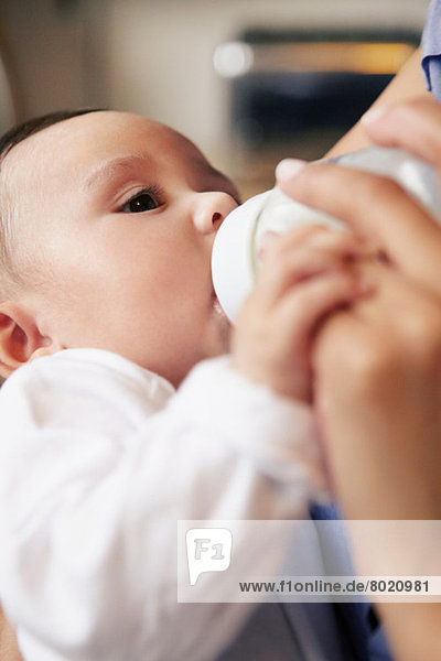 Baby girl drinking bottle of milk