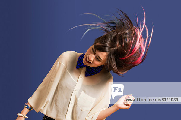 Porträt einer jungen Frau mit gefärbtem Haar tanzend