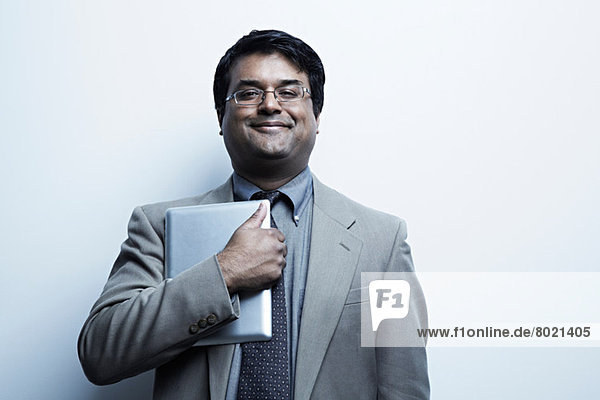 Studio portrait of businessman holding digital tablet