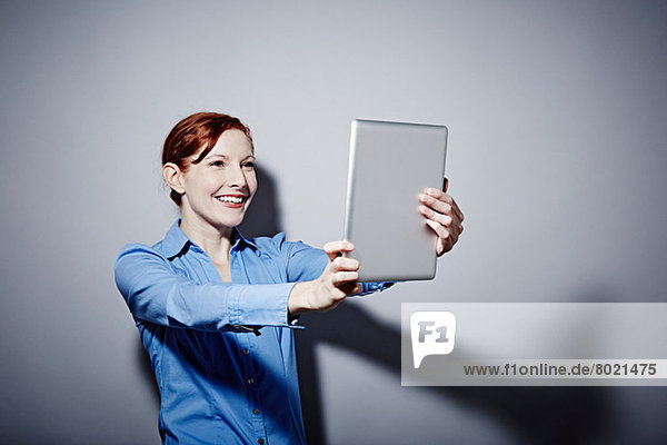Studio-Porträt einer jungen Frau mit digitalem Tablett