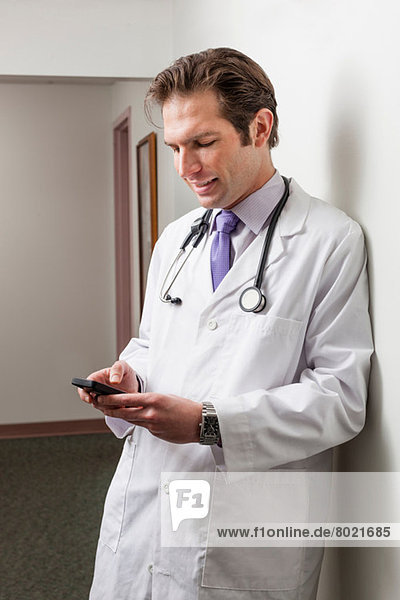 Arzt mit Handy im Krankenhausflur