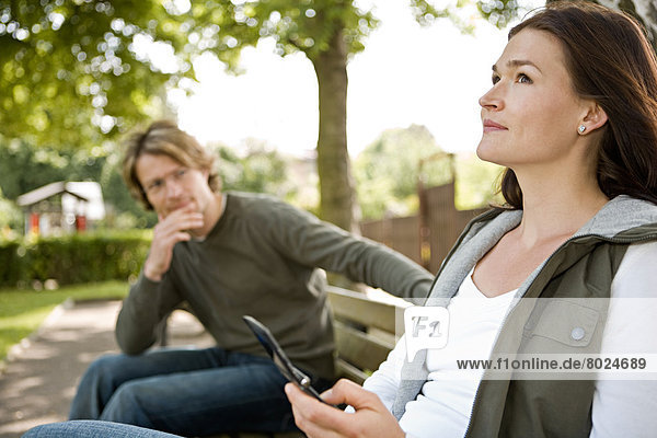 A young woman and a young man are flirting in the park.