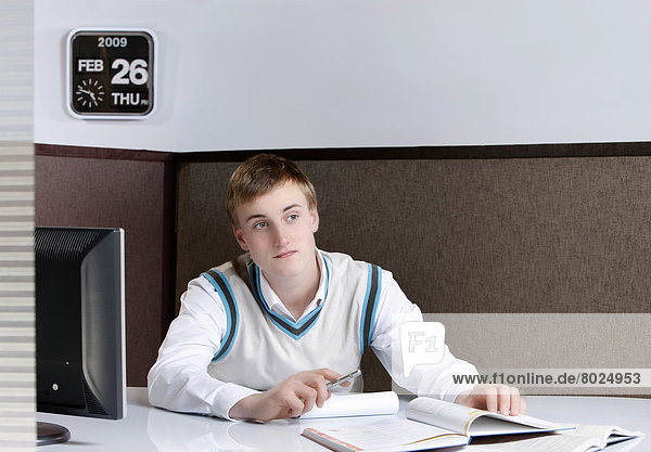 Young man sitting at his desk.