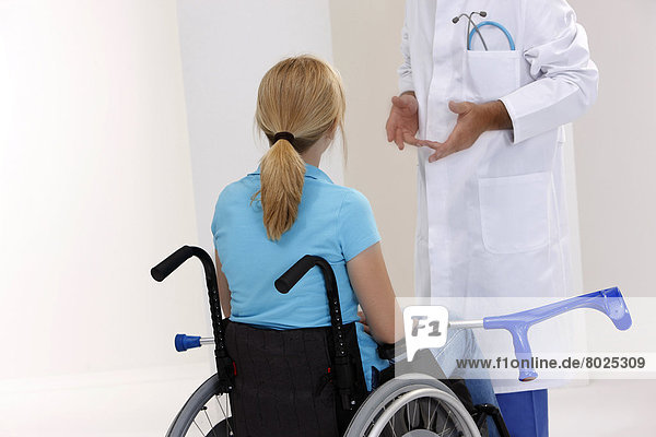 Eine Frau im Rollstuhl beim Arzt