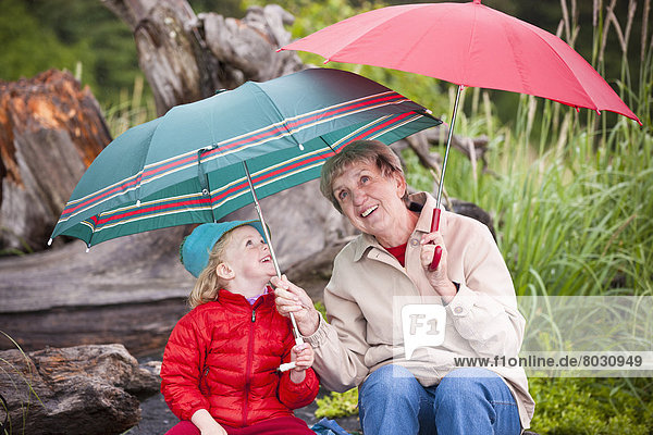 Vereinigte Staaten von Amerika  USA  sitzend  Tag  Spiel  Strand  Sommer  Regenschirm  Schirm  Regen  Enkeltochter  Großmutter  zeigen  Sonnenschirm  Schirm