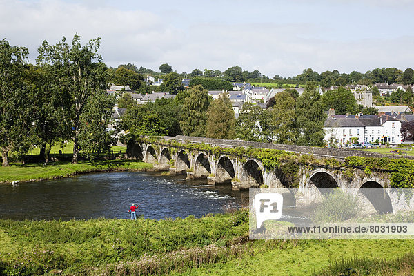 A bridge crossing the river nore with a man fishing at the water's edge Inistioge county kilkenny ireland