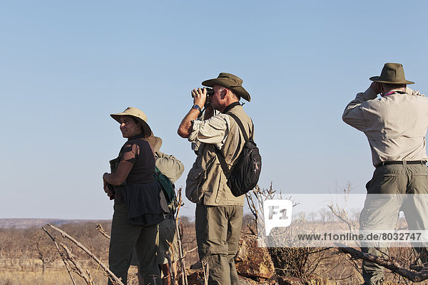 Africa  Zimbabwe  Hwange National Park  People using binoculars on a safari.
