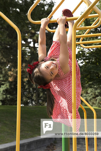 Young Asian-Caucasian Girl Hanging Upside Down On Playground Equipment  Ontario Canada