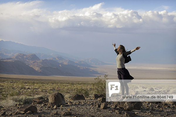USA  California  Woman standing with arms raised  Death Valley National Park
