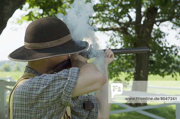 Man wearing period costume with musket gun in Ash Lawn-Highland  Charlottesville  Virginia  USA
