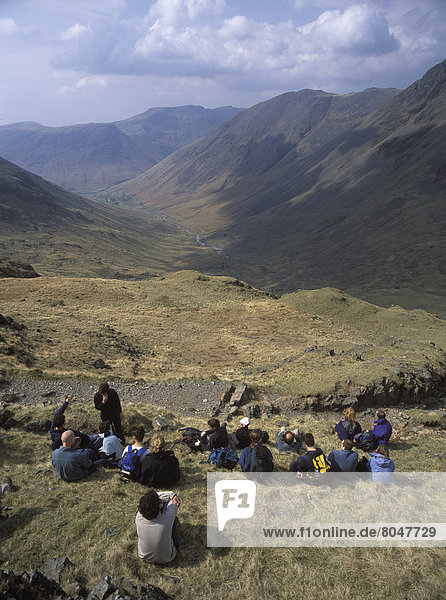 Large Group Of Walkers Resting On The Way Up Scafell Pike  Lake District  Uk.