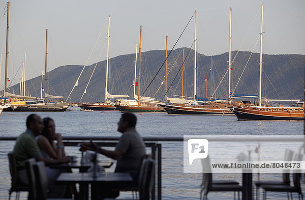 am Tisch essen Boot vertäut Ansicht Strand Bucht Bodrum Türkei