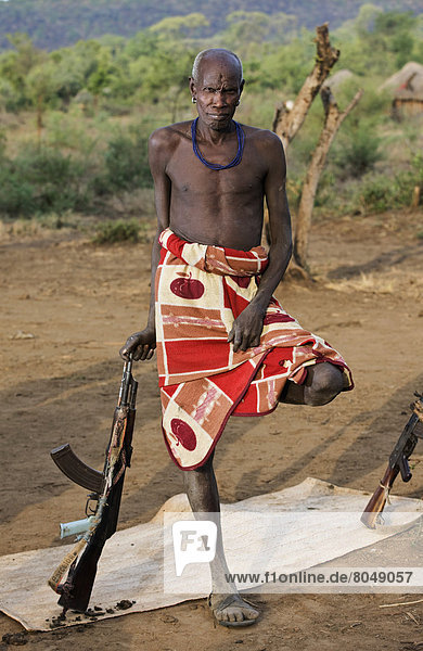 Ethiopia  Southern Nations Nationalities and Peoples' Region  South Omo  Mursiland  Portrait of Mursi tribal man with gun  Maridungka village