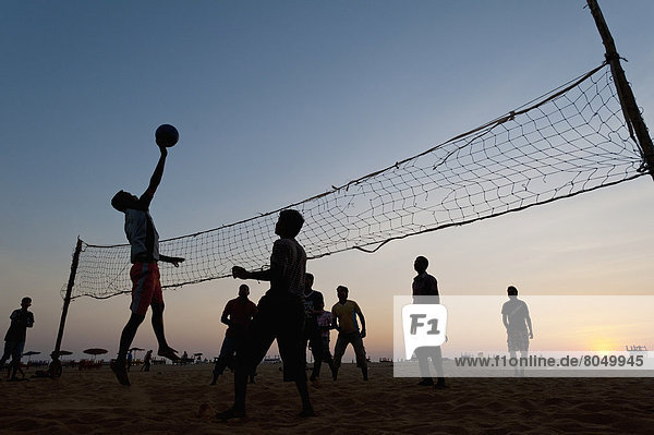 Mann Spiel Strand Volleyball Abenddämmerung Goa Indien
