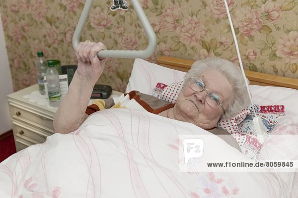Alte Frau liegt im Krankenbett  Portrait