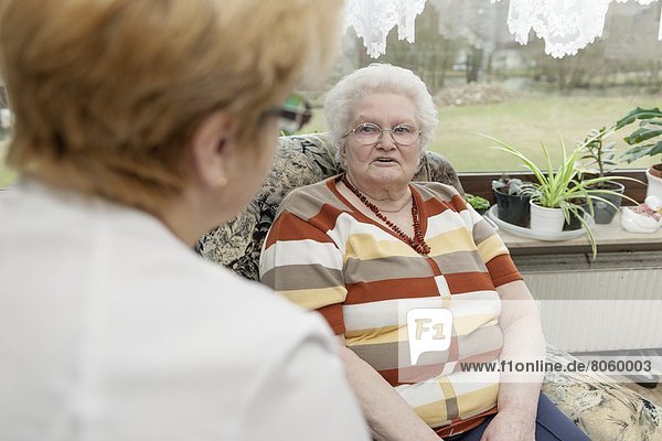 Altenpflegerin spricht mit einer alter Frau